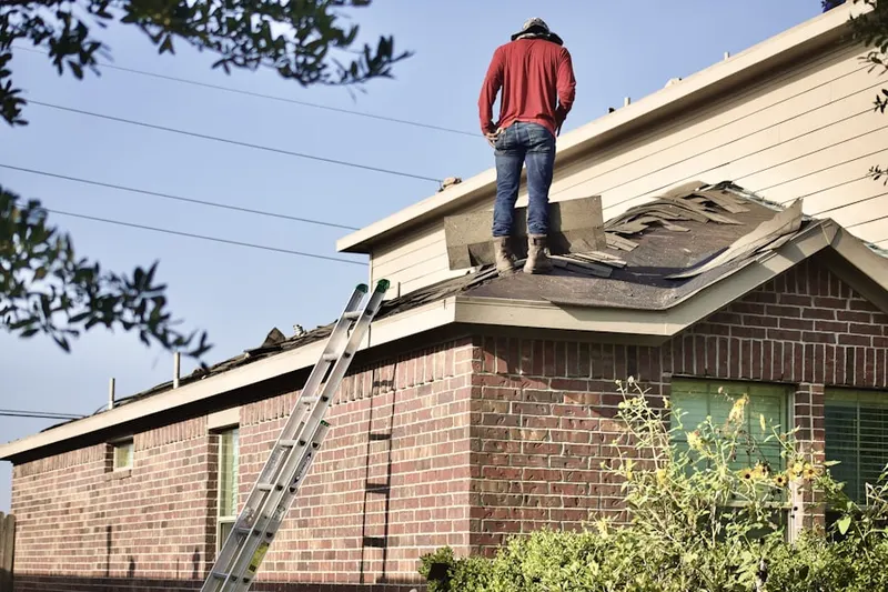 Professional roofer working on a residential roof in Charleswood